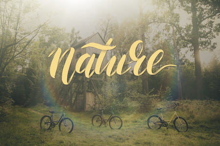 Composite image with overlaid hand drawn lettering. Word Nature on background forest landscape with bicycles. Morning walk, travel, adventure. Inspirational  poster for your designの写真素材