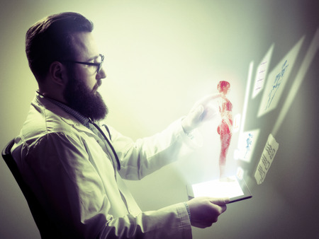 Concept of modern diagnostics and treatment methods. Doctor examines patient using most modern methods of diagnosis and analysis. All information about patient's problems displayed in a digital form.の写真素材