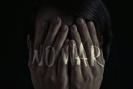 Concept of "no war". Dim light and black  background , creates a dramatic mood of this  image. On image there is  inscription "no war".の写真素材