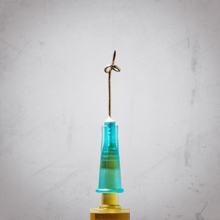 Concept "stop drugs". Needle with knot, close up. Image on scratched light background.の写真素材