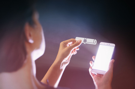 Image of a woman with a smartphone in her hand. She holds certificate icon. Concept of modern ...