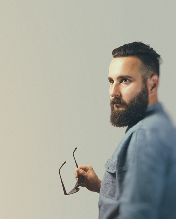 Black and white portrait in profile of a bearded man in a denim shirt.の写真素材