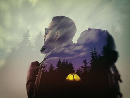 Photo of stylish bearded traveler looking into the distance. Double exposure, beautiful mountain landscape background. Made in vintage style.の写真素材