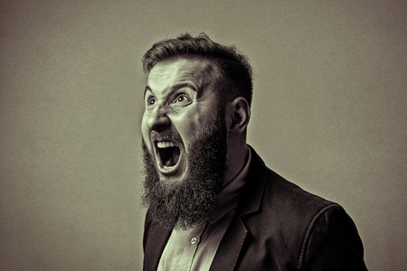 Concept of anger. Bearded man in suit shouts in a state of anger. Black and white image in vintage style.の写真素材