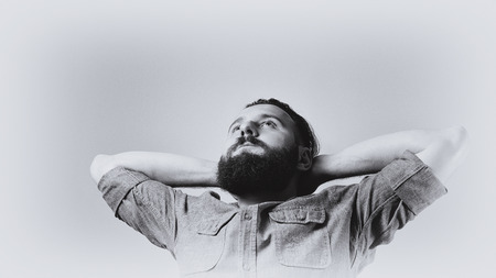 Black and white portrait of a bearded man in profile. The man has a stylish haircut and a neat beard. の写真素材
