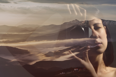 Portrait of a woman with a camera. Double exposure, beautiful mountain landscape background. Made in vintage style.の写真素材