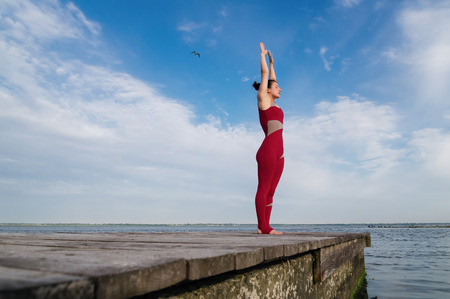 Young woman practicing yoga on the beach