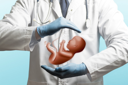 Image of a doctor in a white coat and baby above his hands. Care of the infant.の写真素材
