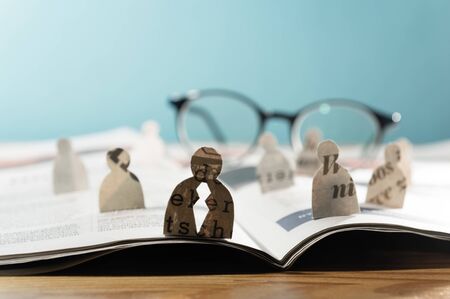 Business recruitment or hiring photo concept. Looking for talent. Icons of candidates are standing on open newspaper under glasses.の写真素材
