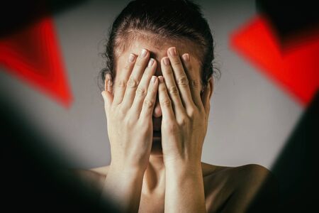 The woman covers her face. Concept of suffering, grief, fear, etc.