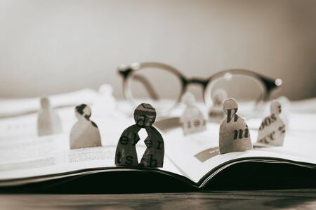 Business recruitment or hiring photo concept. Looking for talent. Icons of candidates are standing on open newspaper under glasses.の写真素材