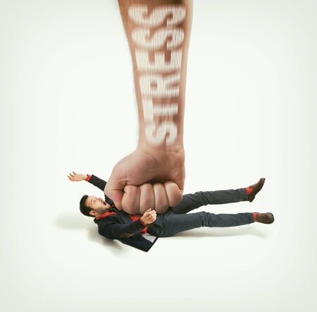 The big human fist with text - stress bring down the man off his feet. Concept of emotional exhaustion, stress. Image.の写真素材