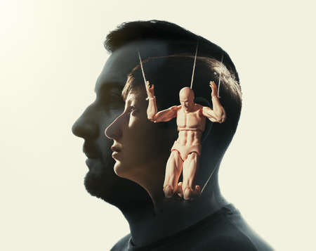 Multiple exposure with man and woman silhouette and marionette with rope on her hands. Concept of control.の写真素材
