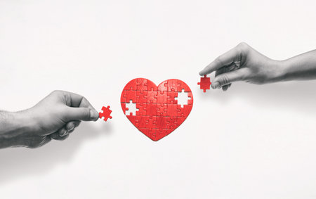 Two people put together a heart-shaped puzzle. The concept of building love relationships.の写真素材