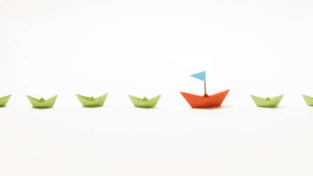 Orange paper boat among of a group of green paper boats on white background. Concept of leadership,...