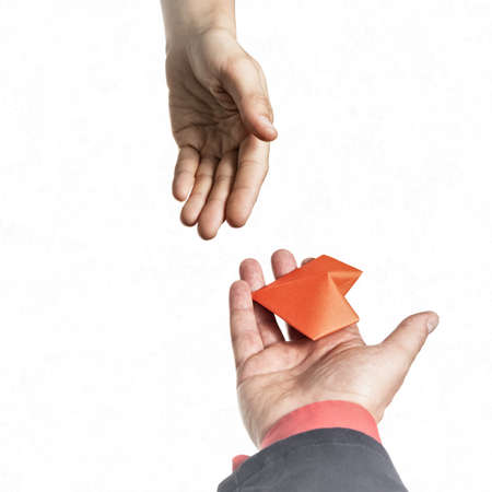 Red heart in woman and man hands. Concept of love, giving gifts, donorship.の写真素材