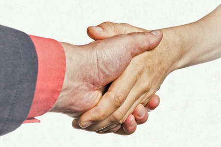 Hands of a man and a woman are connected by a handshake. Metaphor of rescue, love, assistance.