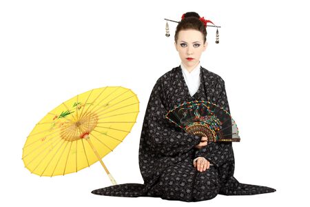 The Japanese geisha on a white background with a fan and an umbrellaの写真素材