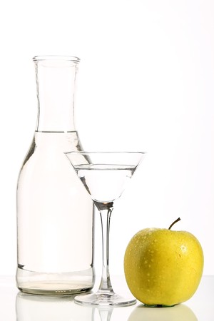Bottle with transparent water, a glass and apples on a white backgroundの写真素材