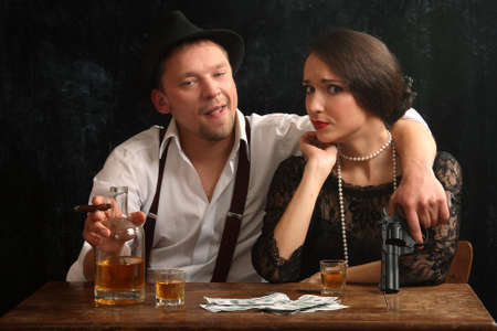 The man-gangster and the beautiful girl talk in a barの写真素材