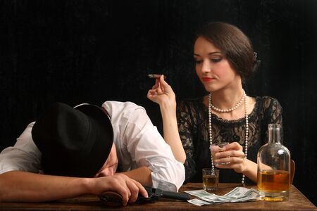 The man-gangster and the beautiful girl talk in a barの写真素材