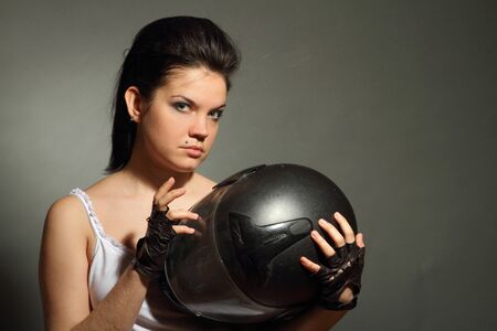 The girl with a motorcycle helmet on a gray backgroundの写真素材
