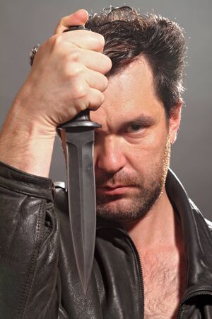 the man the soldier holds in a hand a dagger with a black edge