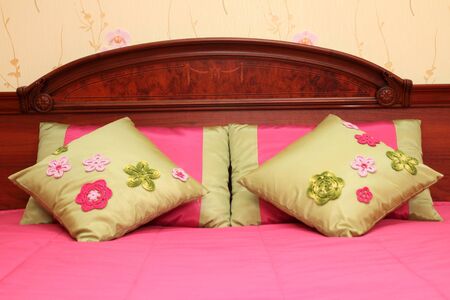 fragment of an interior of a bedroom. a bed headboard with small pillows, a close upの写真素材