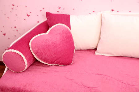 Pink and white pillows on a sofa about a wallの写真素材