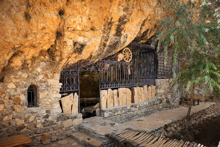 The grotto in the rock which is fenced off by a wall with a lattice and a windowの写真素材