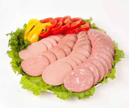 sausage cutting with vegetables and greens on a white plate