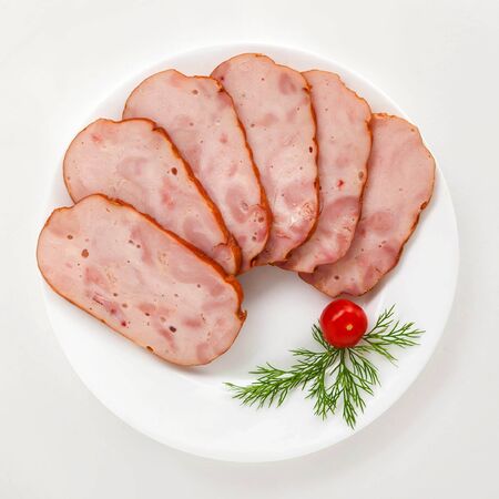 sausage cutting with tomatoes and greens on a white plate