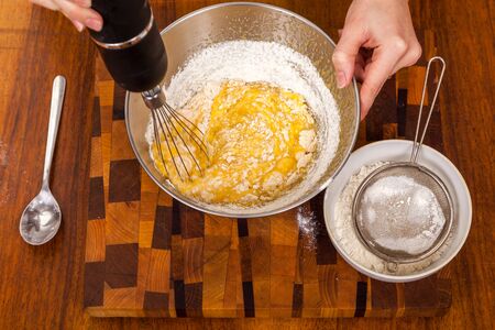 Mixing of ingridiyen for dough the blender on a wooden table