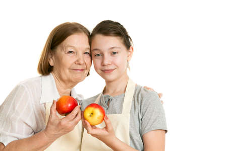the grandmother and the granddaughter hold beautiful apples in handの写真素材