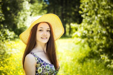 beautiful young brunette woman on the meadowの写真素材
