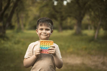 Smiling Boy With Rainbow Walks in the Park. Nice Kid Plays  Outdoor. High quality photoの写真素材