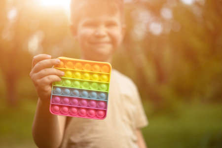 Rainbow . Toddler Boy Shows his Favorite Sensory Toy. Selective Focus of Colorful in Sunny Park. High quality photoの写真素材