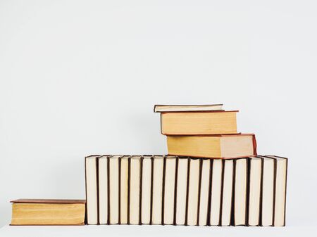 Vintage books with yellow pages on a white table