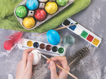 Young mother painting Easter eggsの写真素材