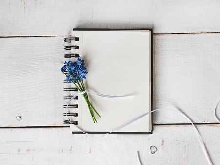 Empty note pad for congratulations to colleagues, friends, relatives and loved ones with beautiful flowers on an isolated, light background. Preparation for the holidayの写真素材