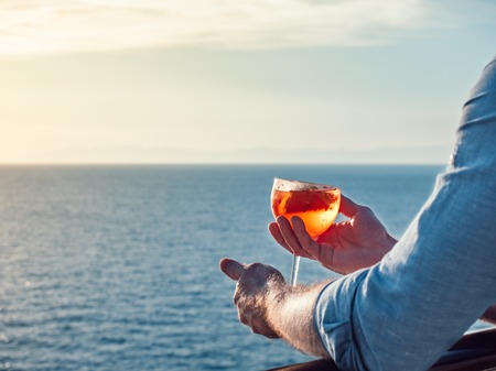 Attractive, stylish man in sunglasses, holding a glass of beautiful pink cocktailの写真素材