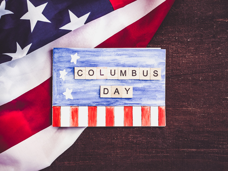 Blank notepad page with a pattern, wooden letters of the alphabet in the form of words Columbus day against the background of the US flag and wooden surface. Close-up. Preparing for the celebrationの写真素材