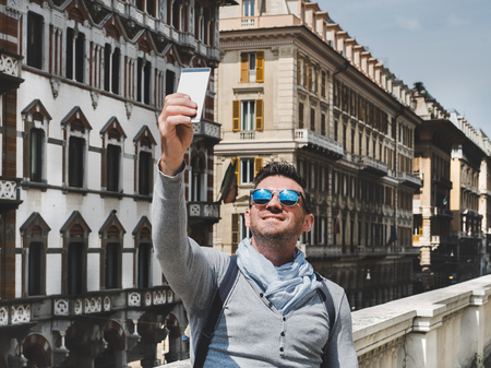 Stylish, happy man with a smartphone. Leisure, travel, positiveの写真素材