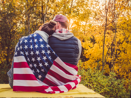 Happy married couple holding the US flagの写真素材
