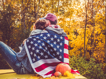 Happy married couple holding the US flagの写真素材