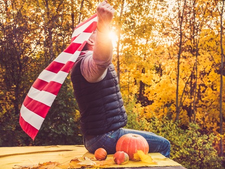 Attractive, stylish man holding a waving US Flagの写真素材