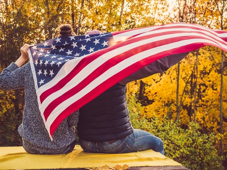 Happy married couple holding the US flagの写真素材