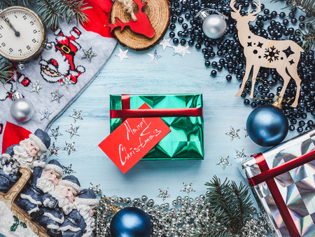 Box with gifts, colorful decorations, multicolored confetti, Christmas tree branches on a wooden, blue surface. Top view, close-up, flat lay. Merry Christmas and Happy New Yearの写真素材