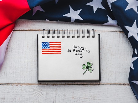St.Patrick's Day. Beautiful card. Notepad with congratulatory inscription. Isolated background, close-up, top view, wooden surface. Congratulations for loved ones, relatives, friends and colleaguesの写真素材
