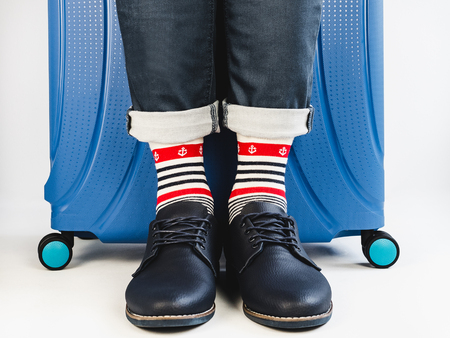 Stylish suitcase, mens legs and bright socksの写真素材